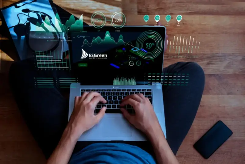 Pessoa usa um notebook com um painel da ESGreen que exibe indicadores de monitoramento